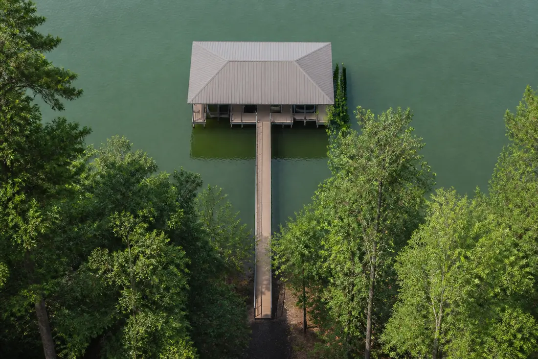 A covered dock at the end of a long walkway seen from above on a Tennessee reservoir