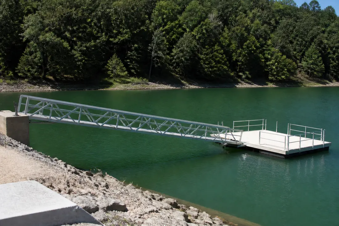 A floating dock connected to the bank by a hinged gangway