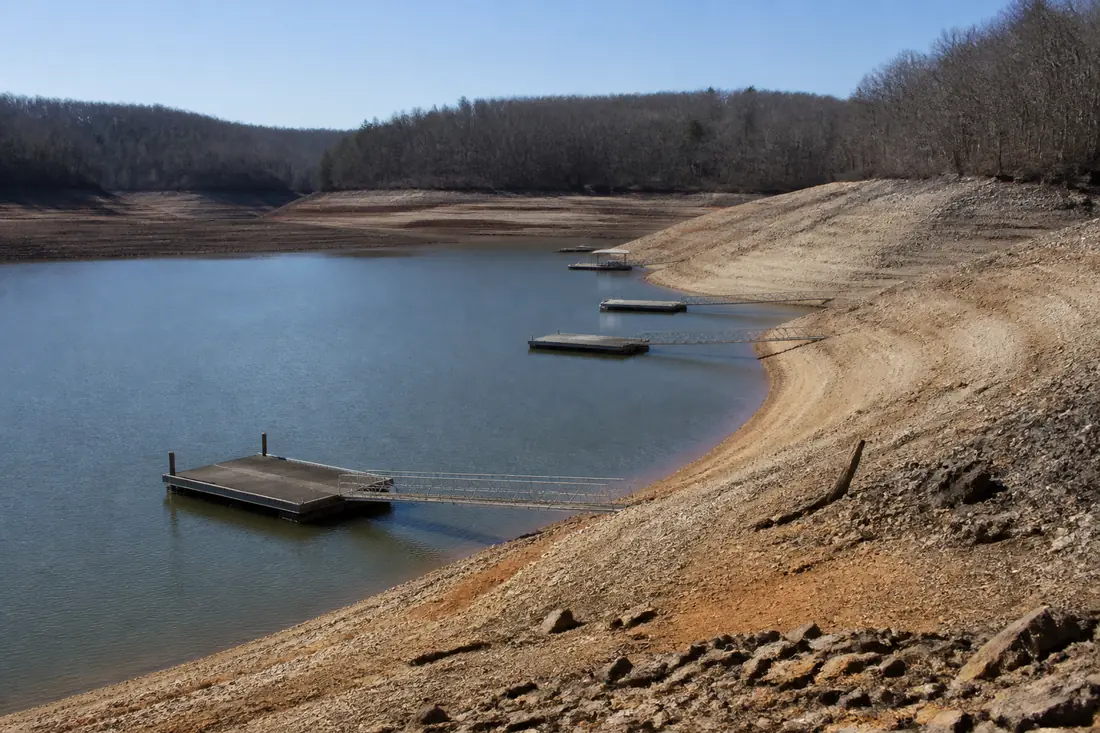 A tributary storage reservoir at winter pool, docks sitting low against exposed banks
