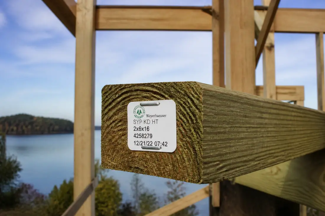 A plastic end tag stapled to the cut end of a treated timber